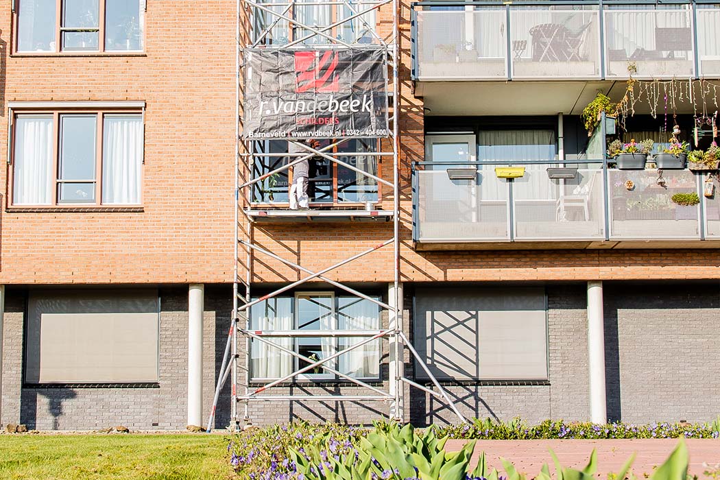 Impressie van een appartementencomplex waar collectief onderhoud buitenschilderwerk wordt uitgevoerd.